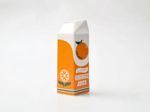 Un vase en céramique vibrant « all-natural orange juice » en forme de brique, orange et blanc, au design minimaliste, avec une tranche d’orange illustrée.