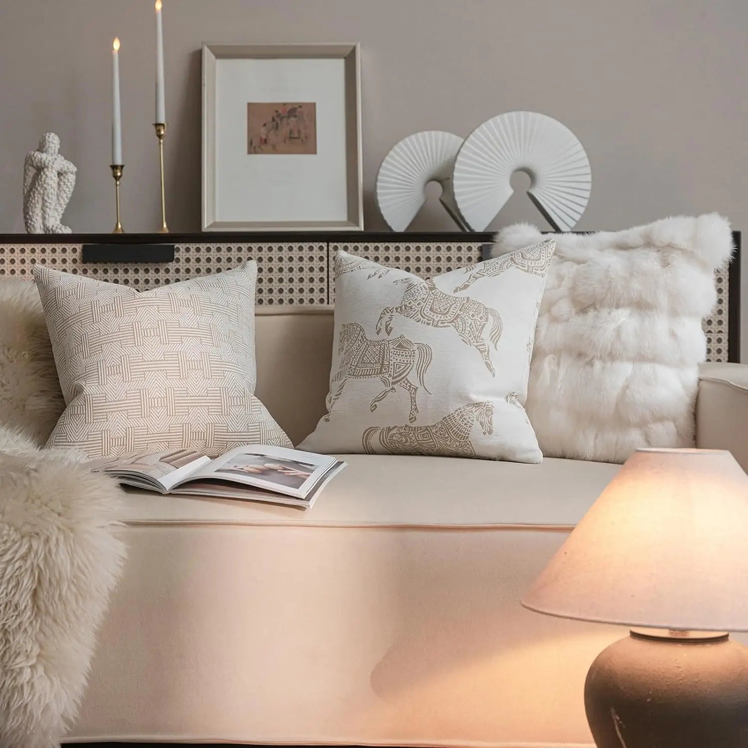 canapé de couleur crème présentant une housse de coussin de luxe couleur lin sec avec un motif tissé en jacquard géométrique, accompagnée d’une couverture blanche moelleuse