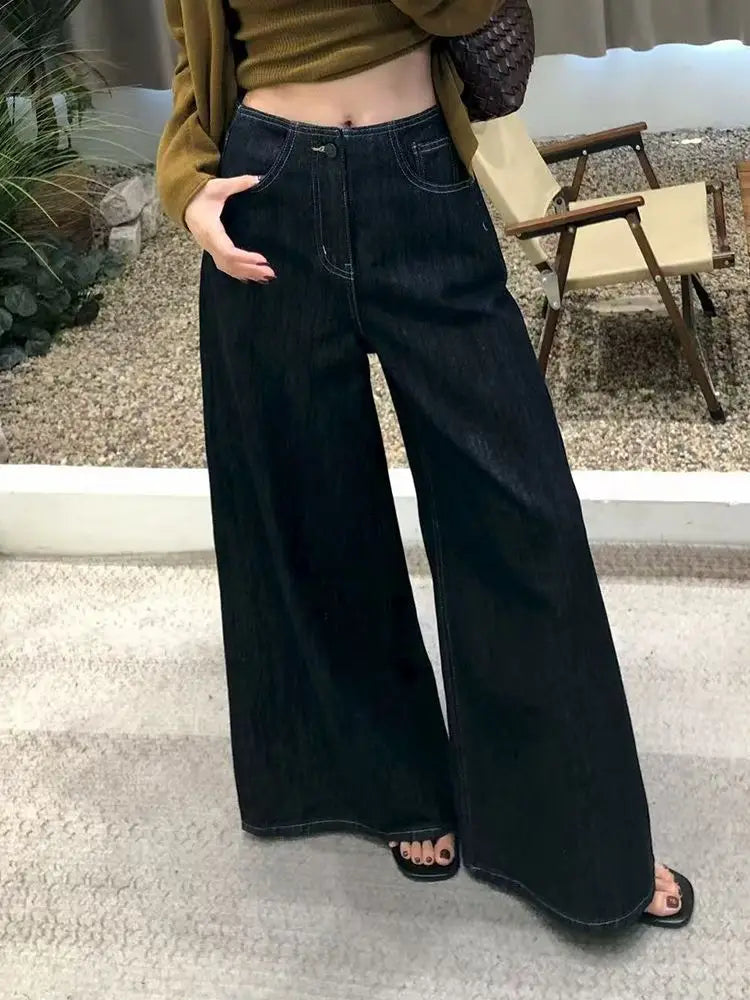 Pantalones vaqueros de tiro alto y pierna ancha en denim de lavado oscuro para mujer, con costuras clásicas y una silueta de pierna ancha.