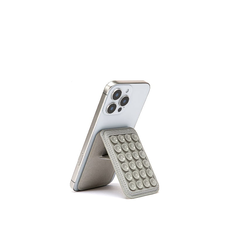 Silver leather foldable magnetic card holder phone stand with a grid of circular suction cups viewed from the front.