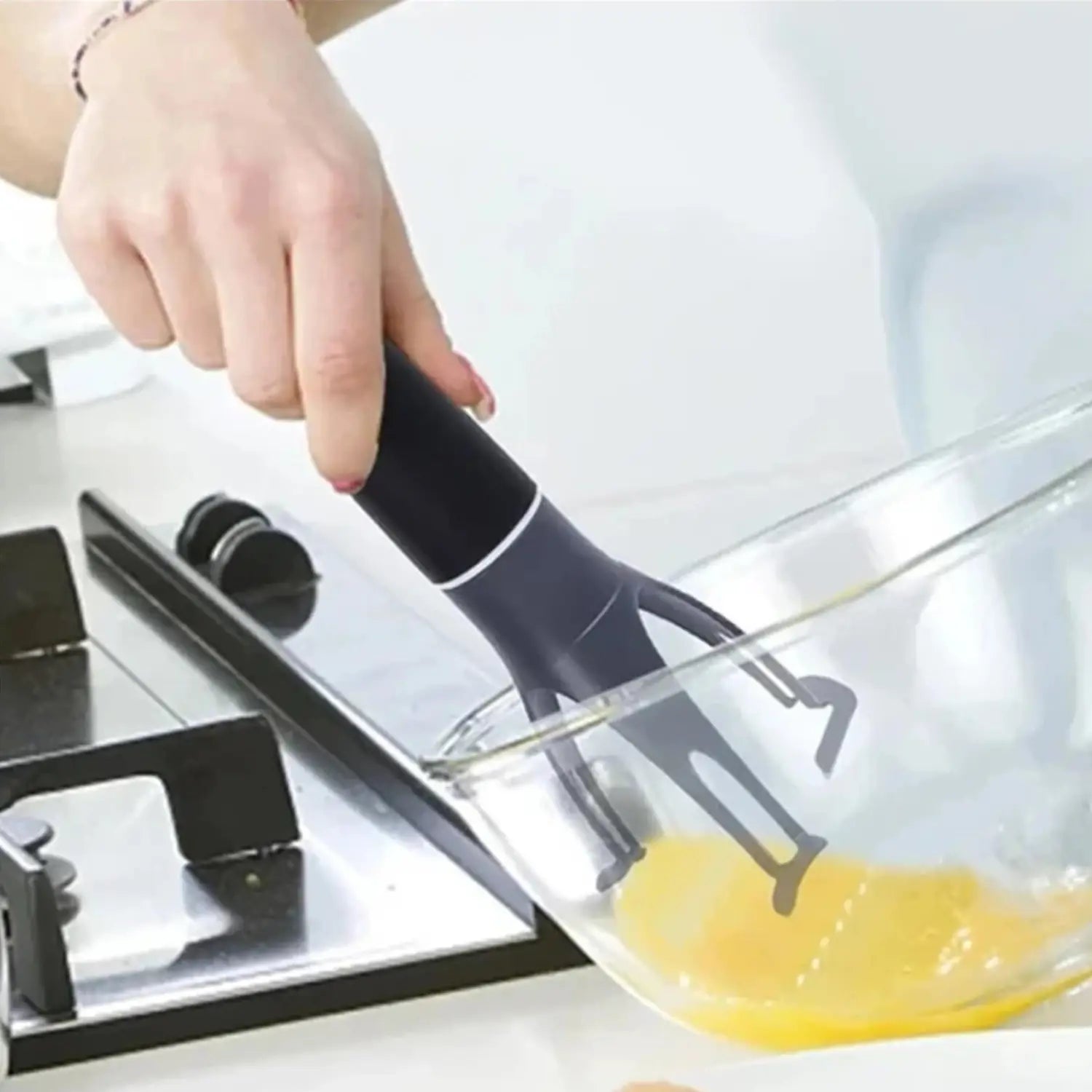 black ergonomic automatic stirrer for pots and pans with a sleek modern design and a three-leg pan stirrer handle featuring subtle white accents
