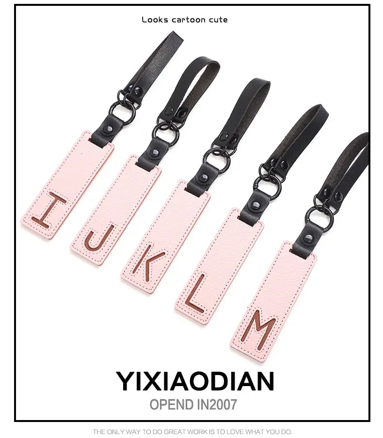 Pink leather luggage tags with black straps and brown monogrammed letters used as letter keychain leather alphabet pendant party gifts.