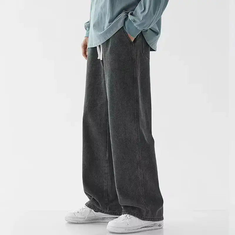 Jeans en denim Y2k à jambes larges et ample pour hommes en gris foncé, coupe décontractée et cordons blancs à la taille.