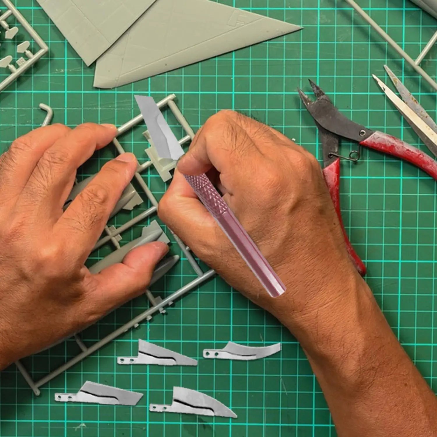 A translucent purple plastic blade from the model craft hand saw kit with four blades held by a hand.
