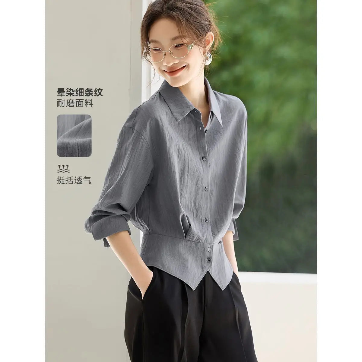 Chemise manches longues grise à texture subtile, coupe décontractée et poignets retroussés, conçue comme une blouse de bureau ajustée pour femmes.