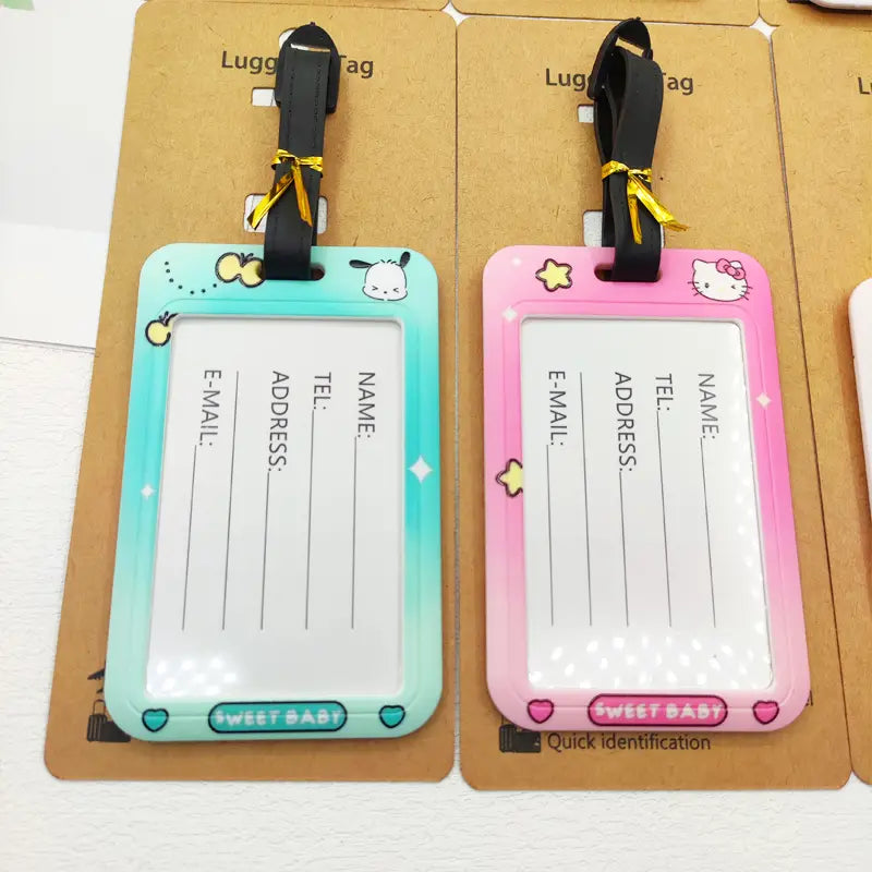 Étiquettes de bagage Hello Kitty en plastique pastel bleu et rose, avec des dessins de personnages de dessin animé et des sangles noires pour les étiquettes d’identification de la valise.