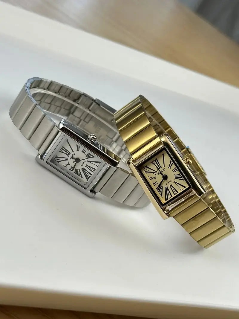 Two rectangular-faced vintage quartz watches for women in silver and gold with cream-colored dials featuring roman numeral hour markers and matching metallic link bracelets.