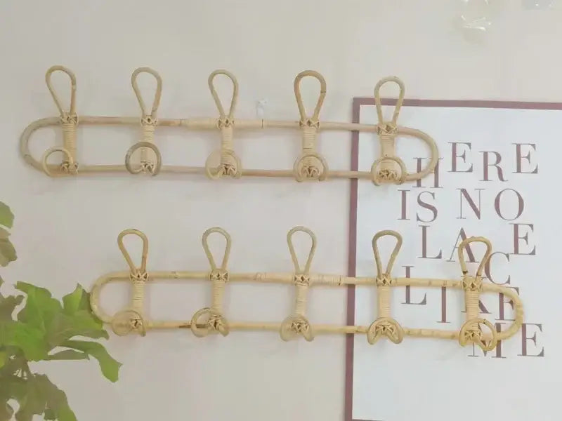 Beiger Rattan-Kinder-Wandhaken zur Aufbewahrung von Kleidung mit fünf Haken und dekorativem geflochtenem Design, an der Wand montiert.