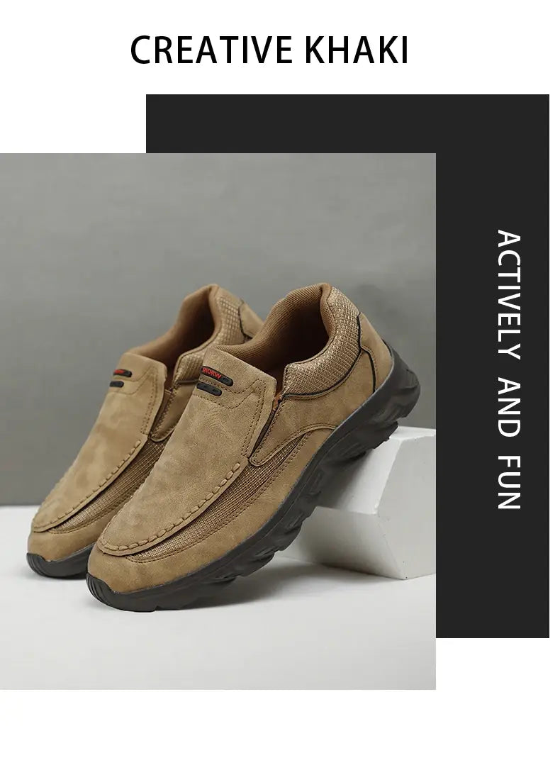 Herren-Lederschuhe im lässigen Stil als Slip-Ons aus beigem Wildleder mit schwarzen Gummisohlen und einem dezenten roten Logos auf der Seite.