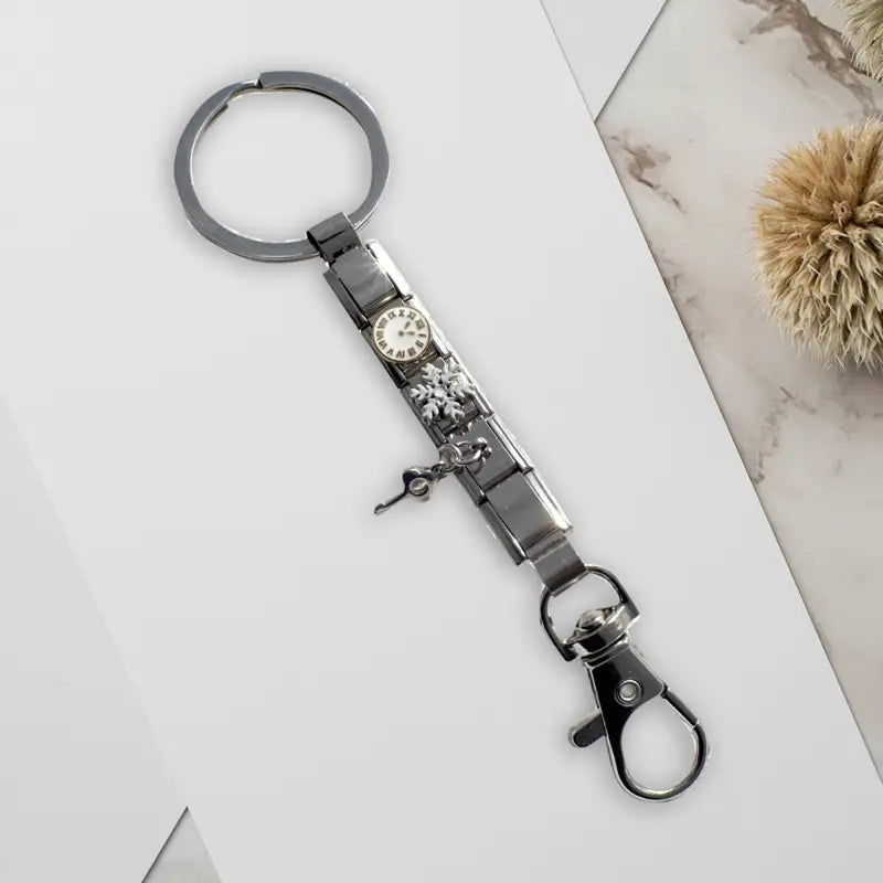 Llavero con dije de eslabones italianos con acabado plateado, con una carátula de reloj en miniatura con números romanos, un dije de copo de nieve y un pequeño colgante de llave para uso personalizado en bricolaje.