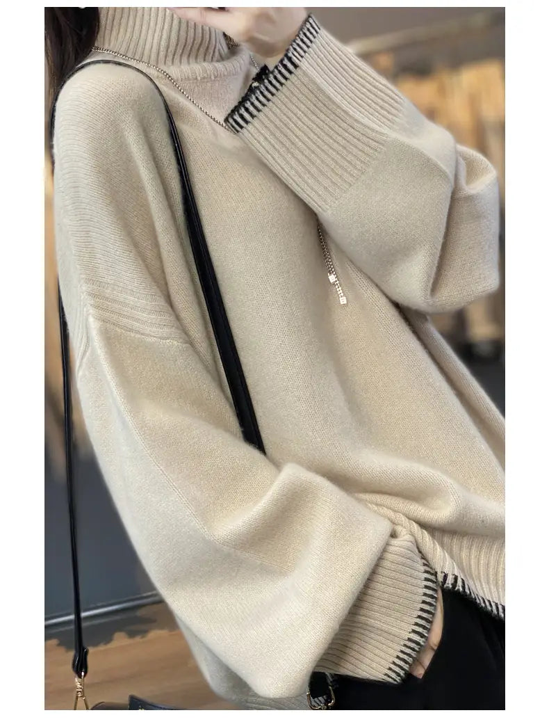 Cream-colored pure wool turtleneck sweater for women featuring an oversized knit design with ribbed cuffs and collar highlighted by a black-and-white striped trim.