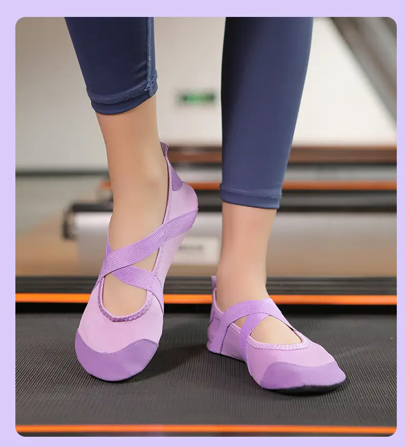 Purple crossover strap women yoga shoes with soft flexible upper and black rubber anti slip soles designed for fitness flats.