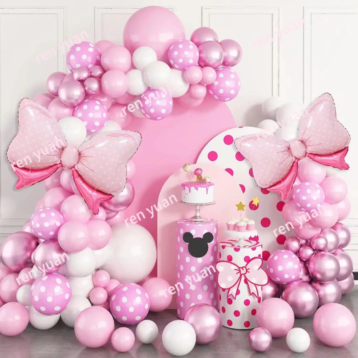 Un kit de arco de globos festivo rosa y blanco con globos de lunares, detalles metálicos brillantes y globos de lámina grandes con forma de lazo para decoración de fiesta.