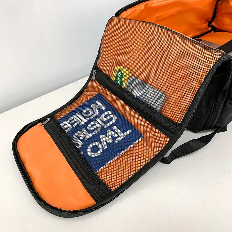 Orange mesh-lined organizer pouch with black zipper trim and interior lining containing a blue two sisters notebook inside a waterproof gym backpack and travel duffel bag.