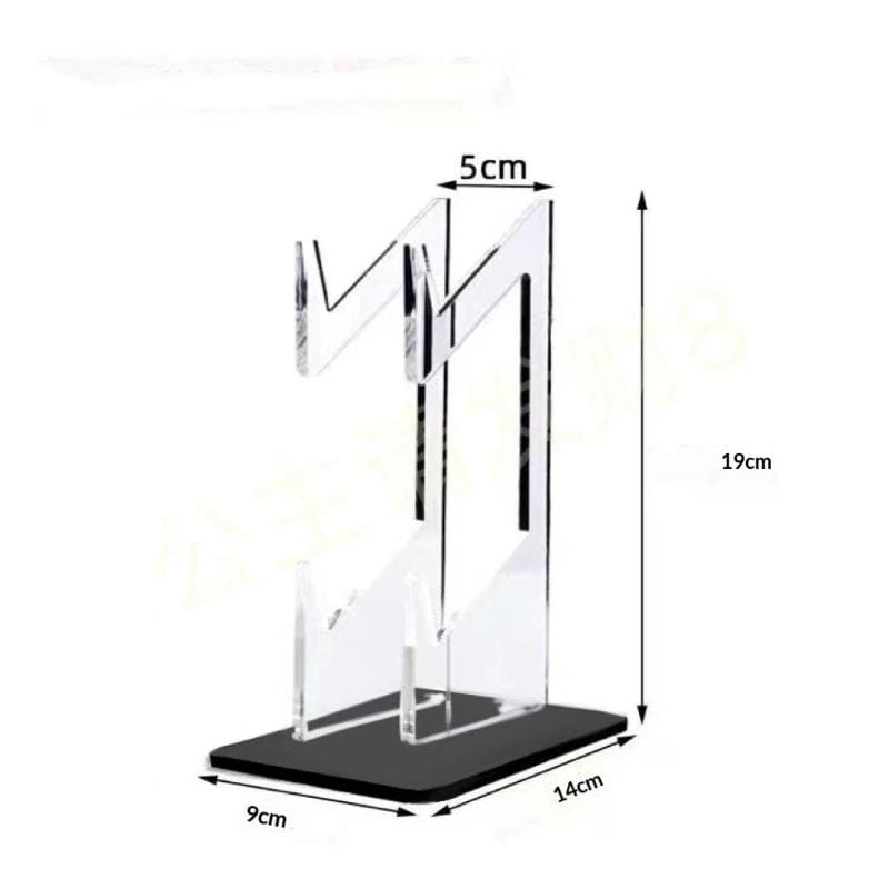 Das Bild zeigt eine transparente Acryl-Halterung für ein Spiel-Controller mit einem schwarzen Sockel, der ein modernes geometrisches Design aufweist, sowie Abmessungen von 19 cm Höhe und 14 cm Breite am Sockel.
