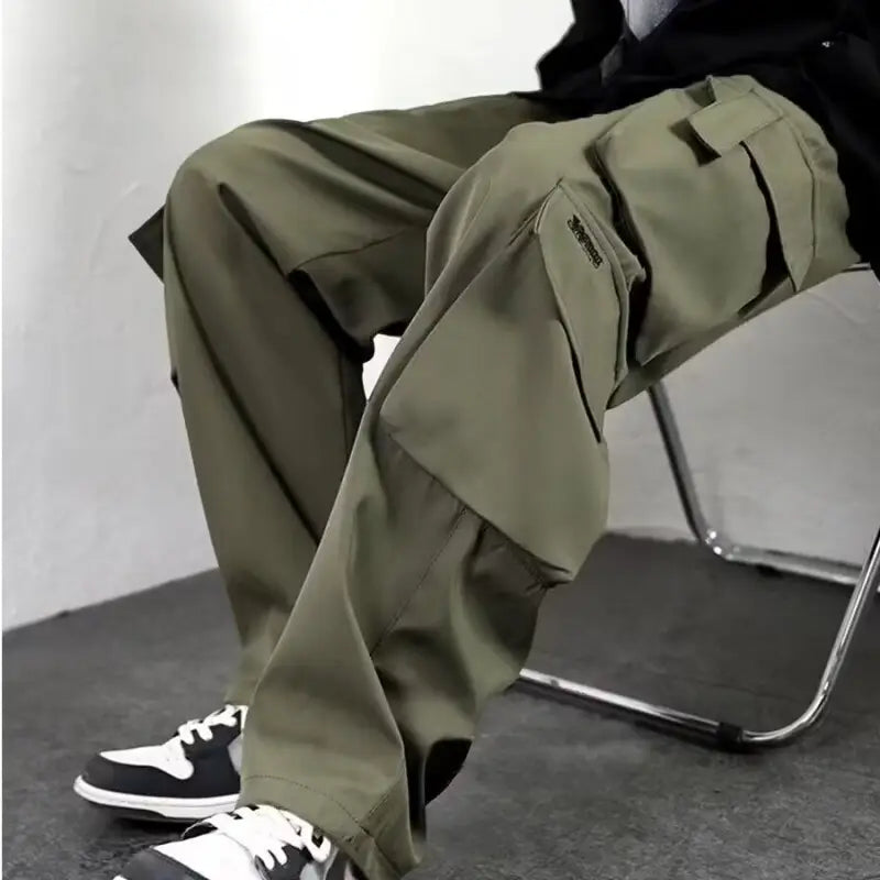 Herren-Cargo-Jogginghosen mit weitem Schnitt, Y2K-Trackpants in Olivgrün, mit mehreren Taschen und einem dezenten Markenlogo auf der Obersatztasche.