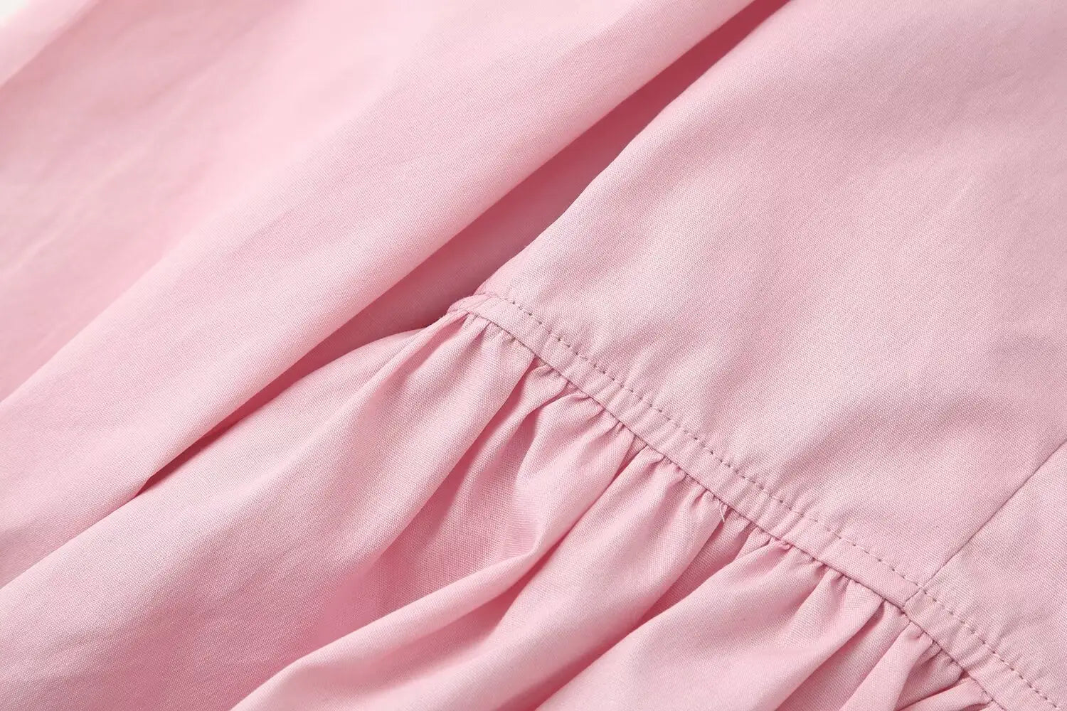 Women slim fit long sleeve round neck top in soft pink cotton fabric with a gentle ruffled hemline and a round neckline design