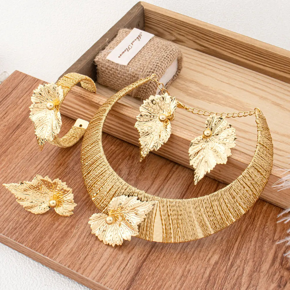 Parure de bijoux en perles et feuilles d’or, comprenant un collier inspiré des feuilles d’or, avec des détails métalliques complexes et des touches de perles.