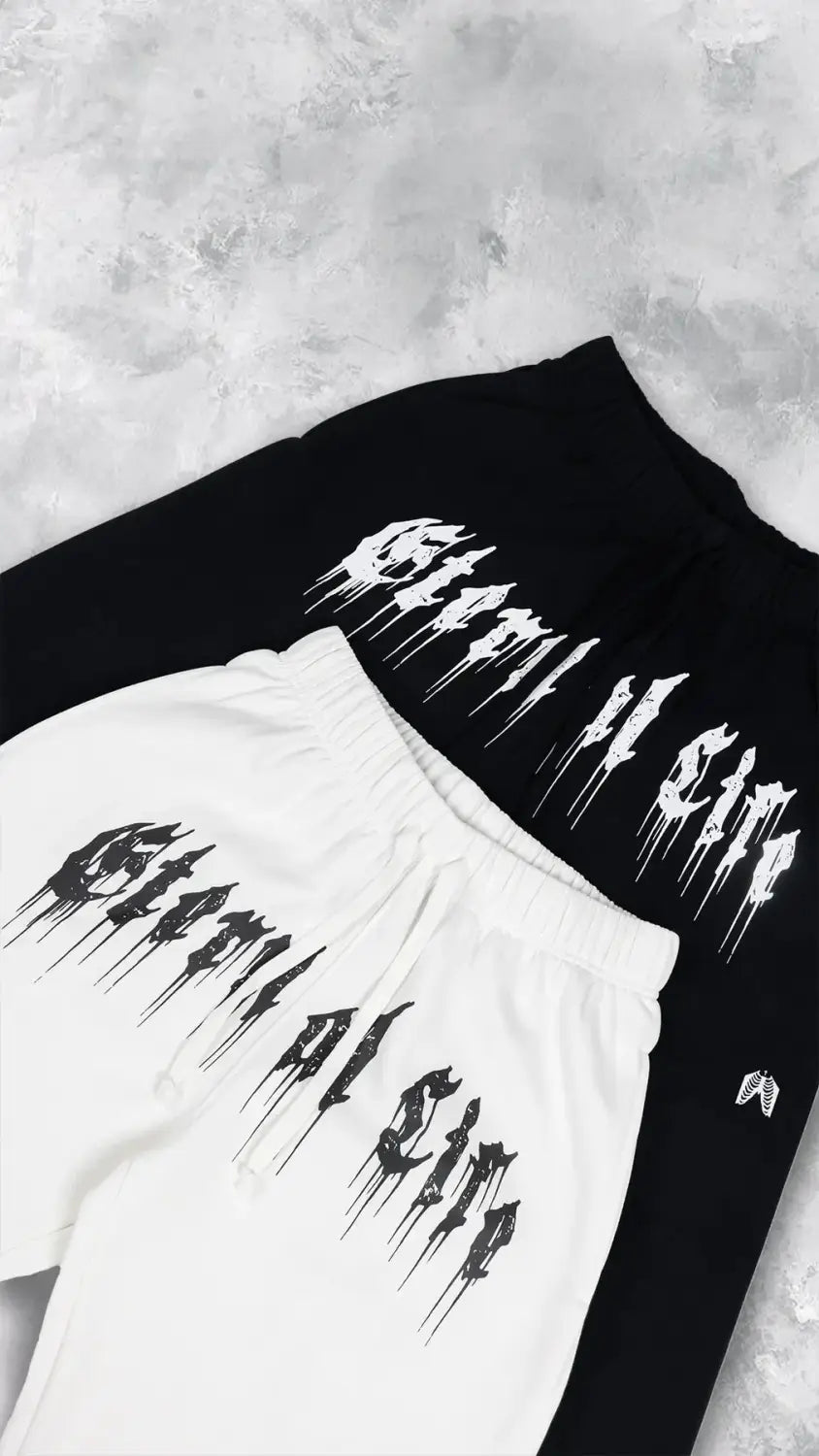 Pantalons d’entraînement graphiques pour hommes, sweatpants noirs et blancs, avec une conception de police audacieuse qui s’écoule, lisant « eternal of sin » sur l’avant, pour un usage en vêtements d’entraînement.