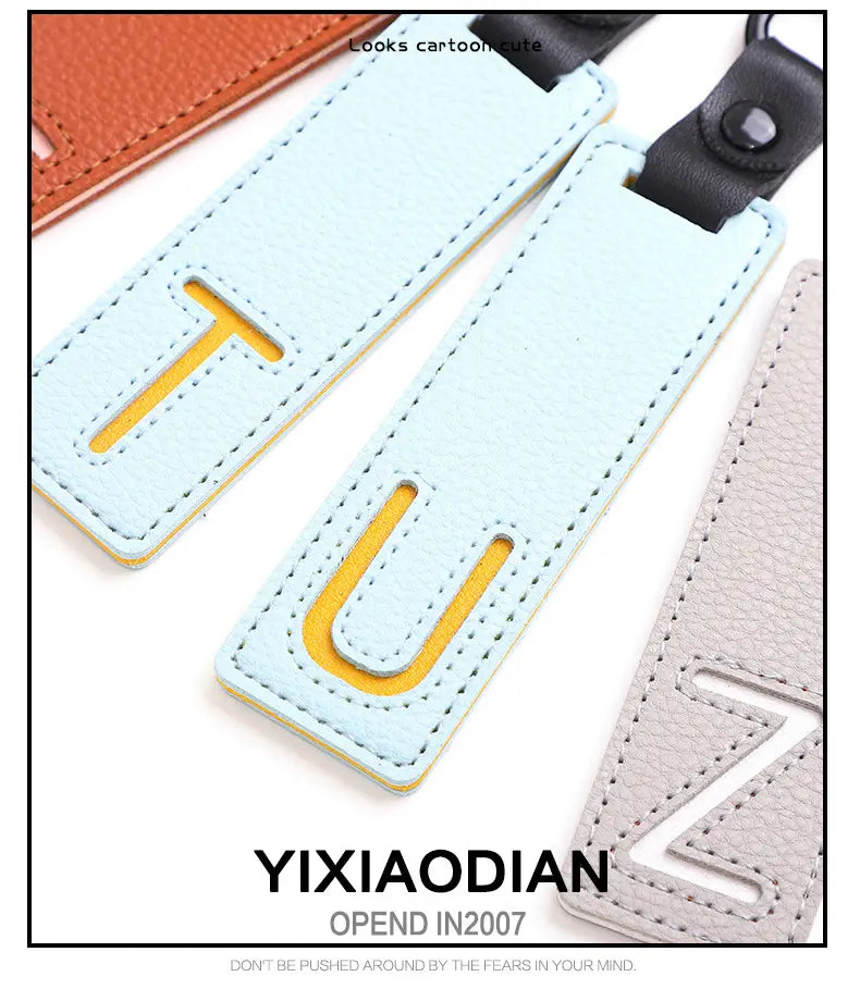Light blue leather luggage tag with a yellow cutout letter t and matching stitching designed as a letter keychain leather alphabet pendant for party gifts.