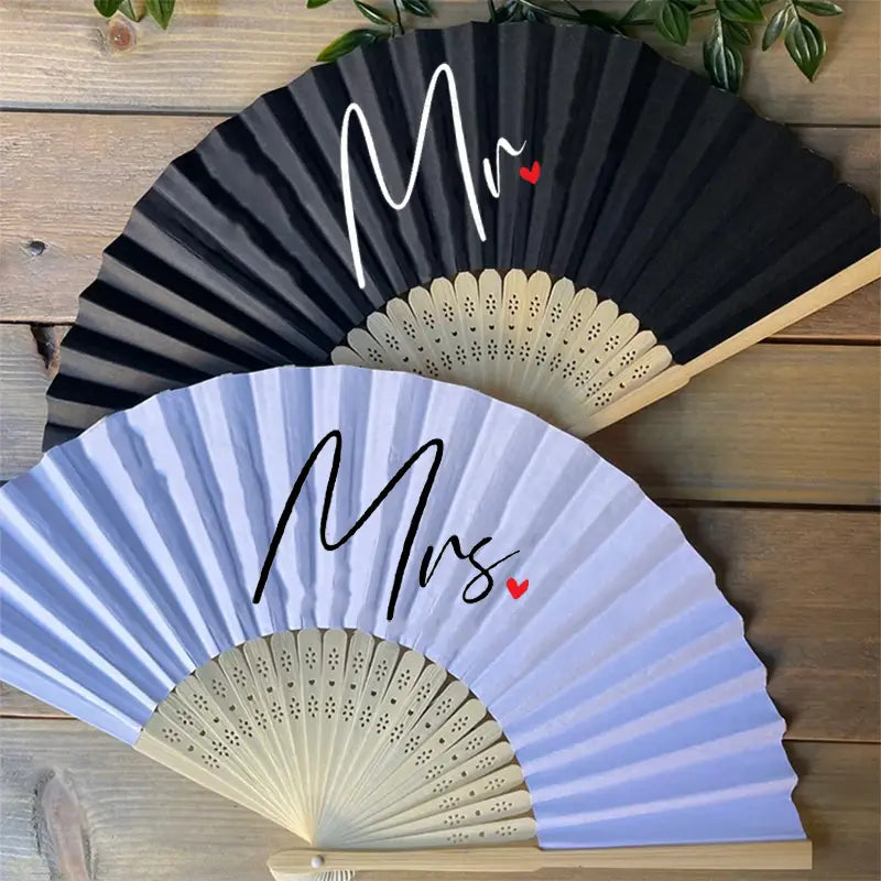Éventails décoratifs pliables noirs et bleu clair, avec « Mr » et « Mrs » dans une écriture élégante, rehaussés de petits cœurs rouges, pour un cadeau aux jeunes mariés