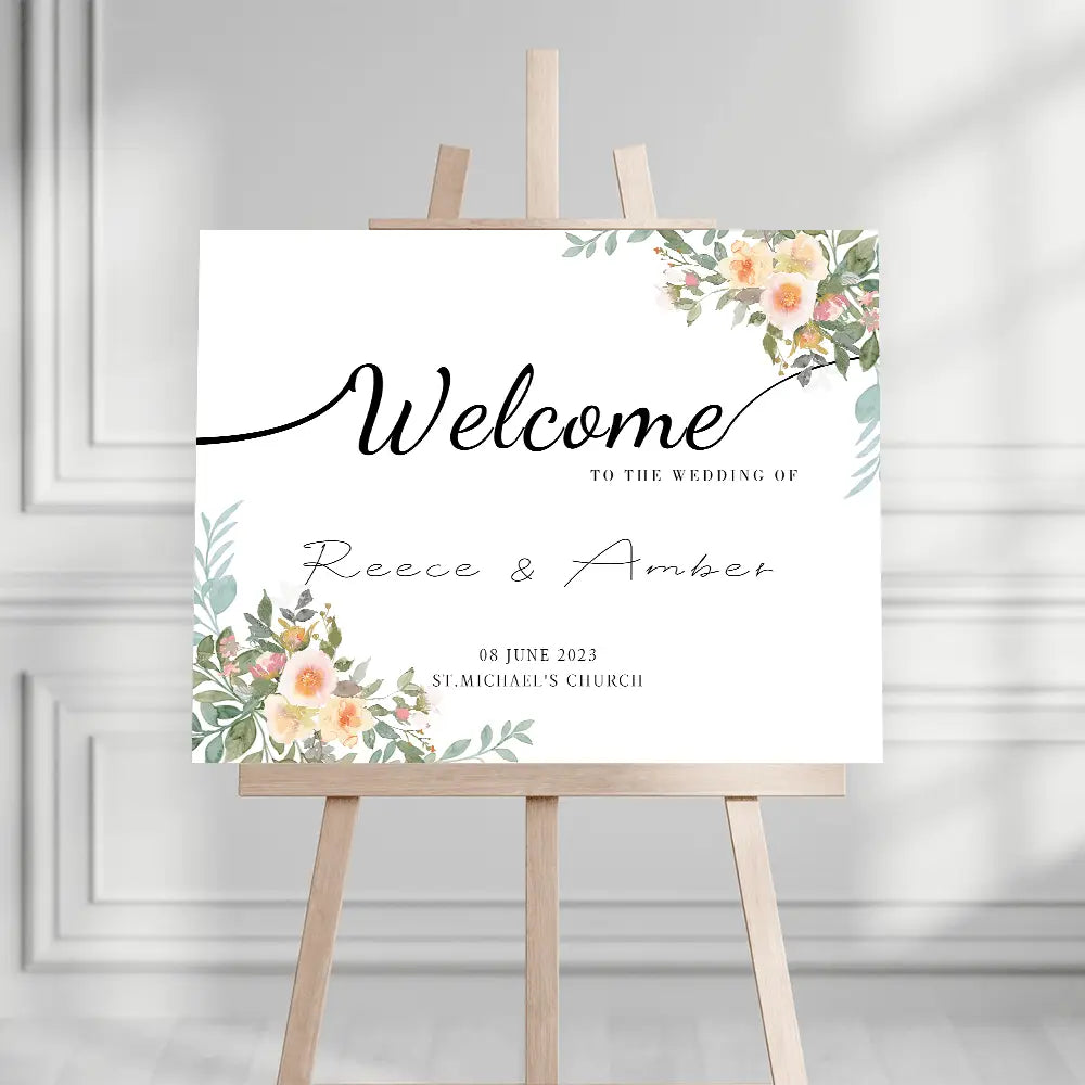 Un panneau d’accueil de mariage blanc personnalisé avec des accents floraux délicats à l’aquarelle dans des tons pêche rosé et vert, comprenant un élégant lettrage cursif noir pour les noms Reece et Amber ainsi que les détails de l’événement.