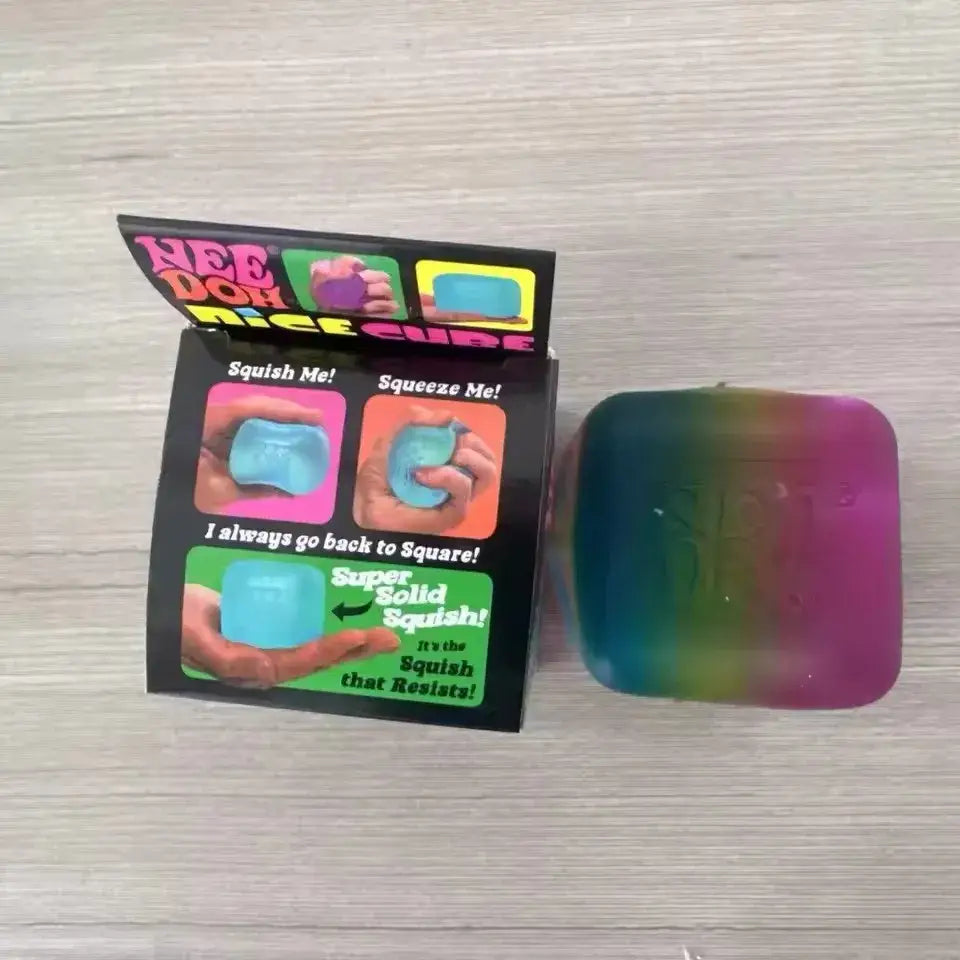 Ein regenbogenfarbenes Needoh-Würfel-Knet- und Fidget-Spielzeug mit glänzender Oberfläche und quadratischer Form, von vorne betrachtet.