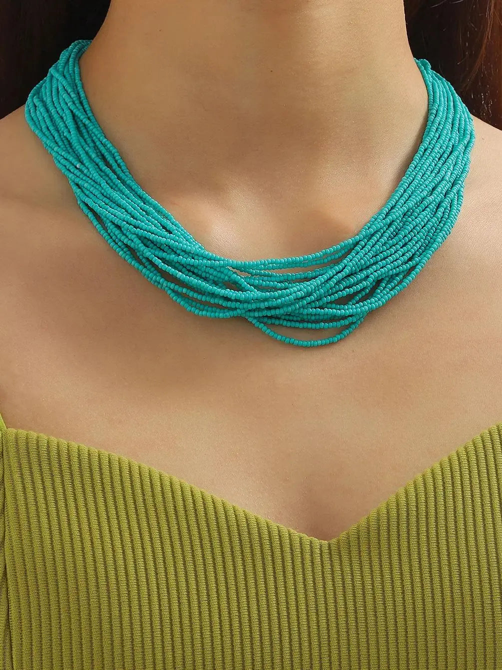 Collier ras du cou boho à plusieurs rangs avec perles turquoise éclatantes, avec plusieurs brins tressés ensemble.