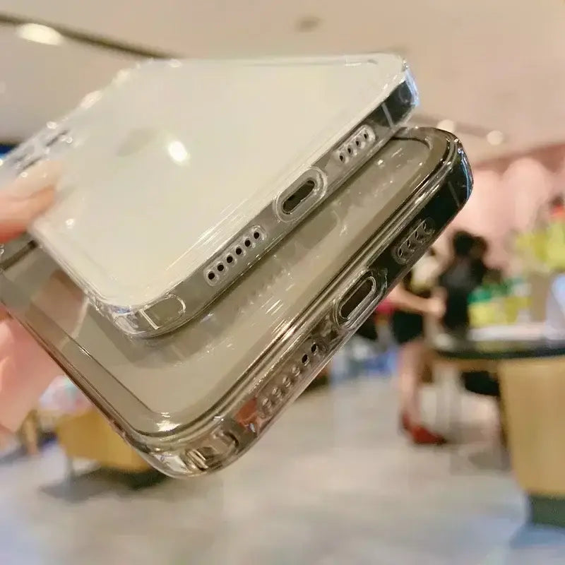 La imagen muestra la parte posterior de estuches protectores transparentes para iPhone con bordes metálicos plateados: uno transparente y otro blanco, de la colección de estuche para iPhone Cherry Blossom Clear.