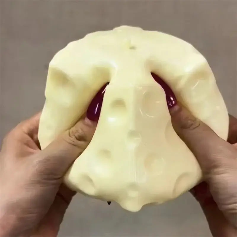 Un juguete antiestrés esponjoso con forma de queso color crema y amarillo, con forma de queso lleno de orificios para el alivio del estrés y el ejercicio de las manos.