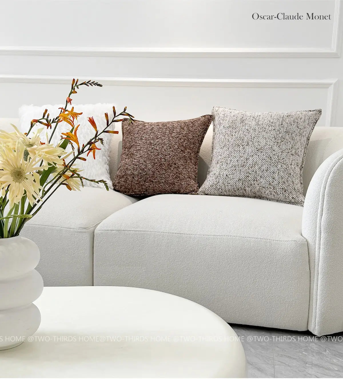 Canapé blanc texturé avec deux housses de coussin d’appoint en chenille en brun chaud et gris atténué pour un rembourrage décoratif.