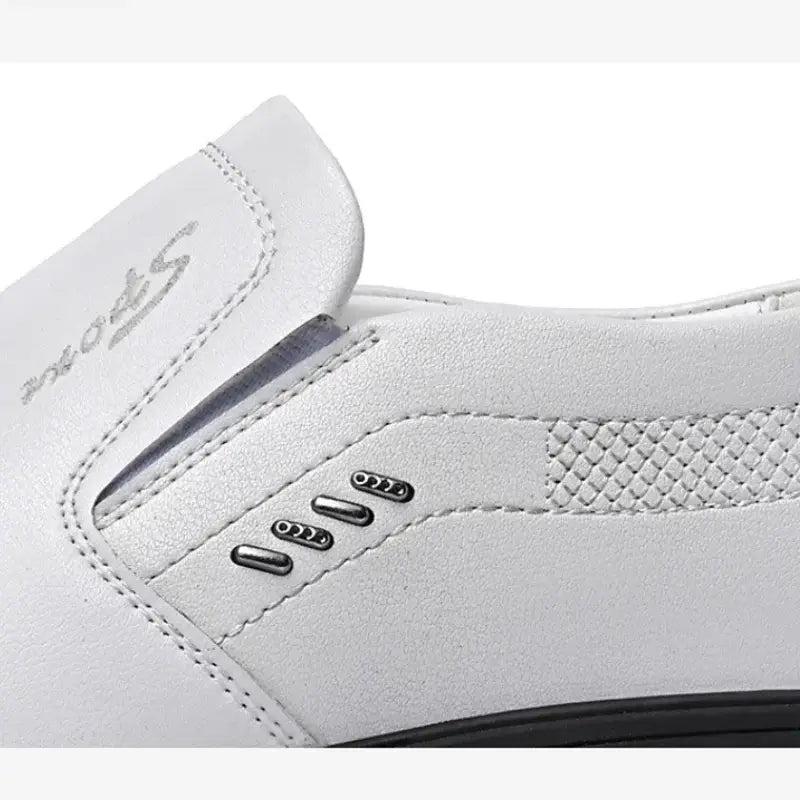 Men leather slip-on driving shoe featuring white leather with silver metallic accents and a subtle textured pattern on the side for casual wear.