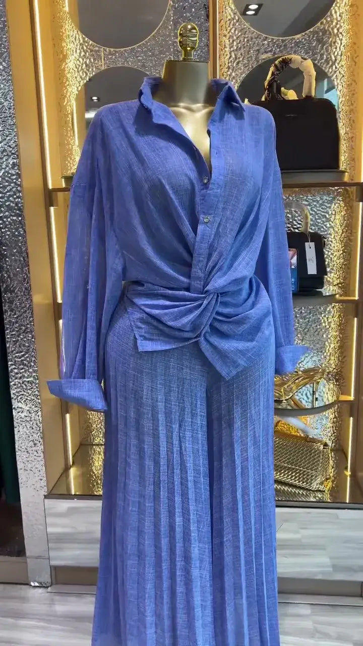 Ein lebhaftes blaues langärmeliges Hemd mit Knopfverschluss und Taillendetail mit Knoten aus dem Damen-Set mit Faltenrockhose im weitem Bein, bestehend aus einem langärmeligen Outfit.
