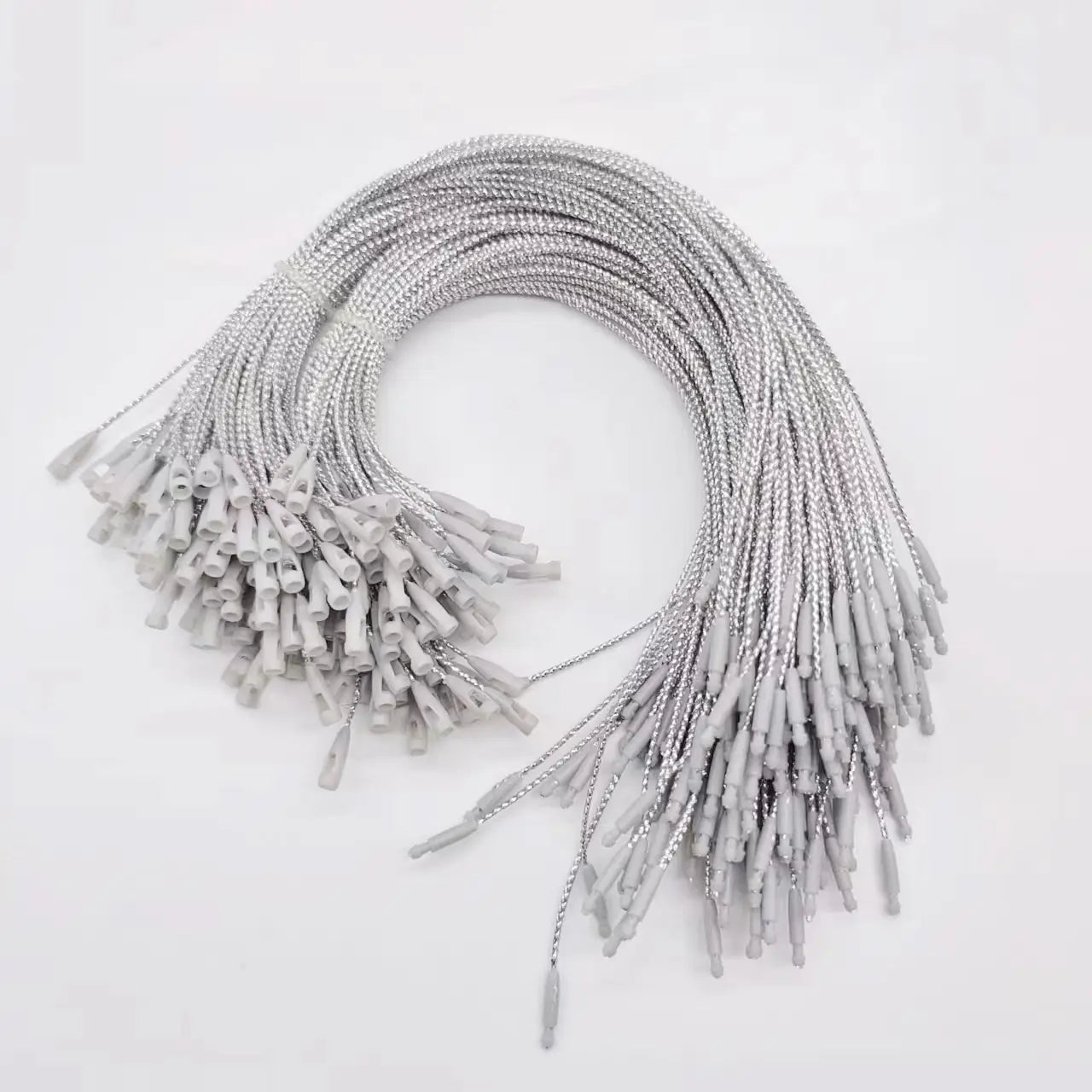 silberfarbene geflochtene Anhängerkettchen mit grauen Kunststoffverbindern, ausgelegt als metallische Aufhängeseile für Weihnachtsbaum-Ornamente.
