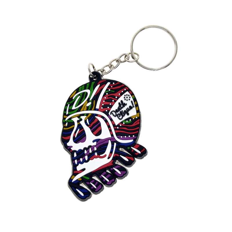 A vibrant multicolored skull-shaped custom soft PVC keychain with a silver metal ring and chain used as a personalized rubber key ring.