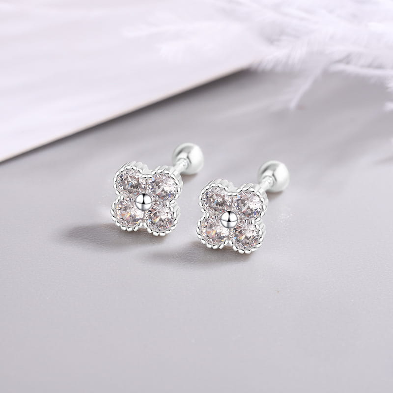 Pendientes tipo clavo de flor de cuatro piedras en plata de ley, con flores plateadas de cuatro pétalos adornadas con piedras de circonita cúbica transparentes.