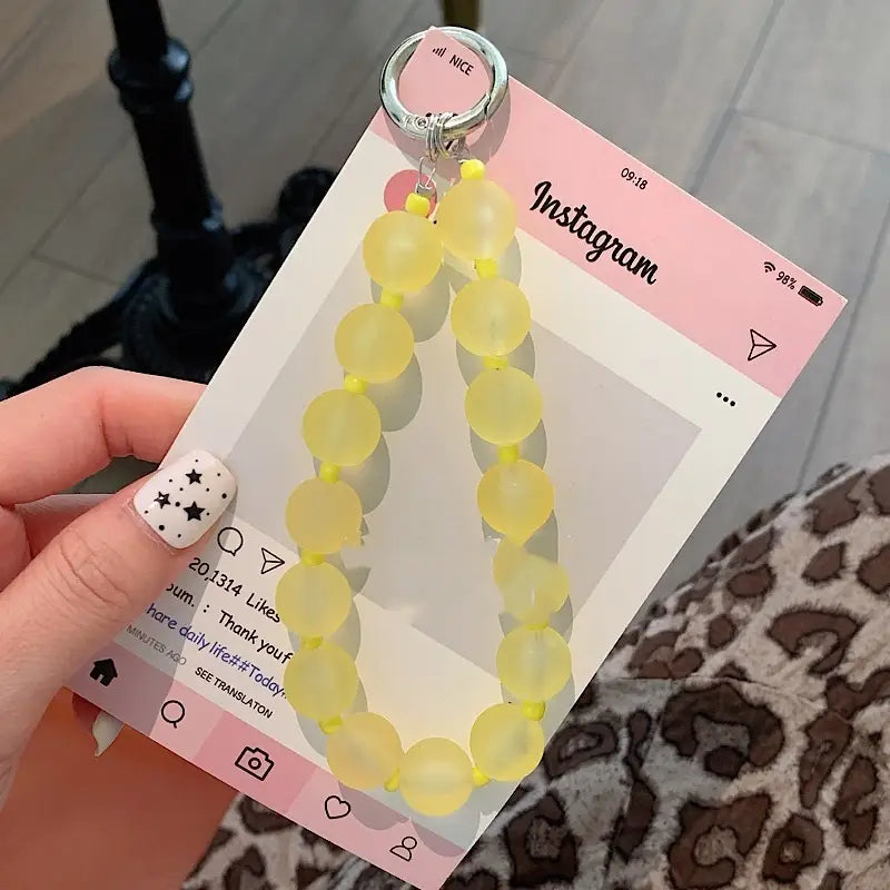 Gelbe, durchscheinende Perlen-Handy-Handgelenksschlaufe mit silbernem Schlüsselring für sicheres Tragen am Handgelenk.