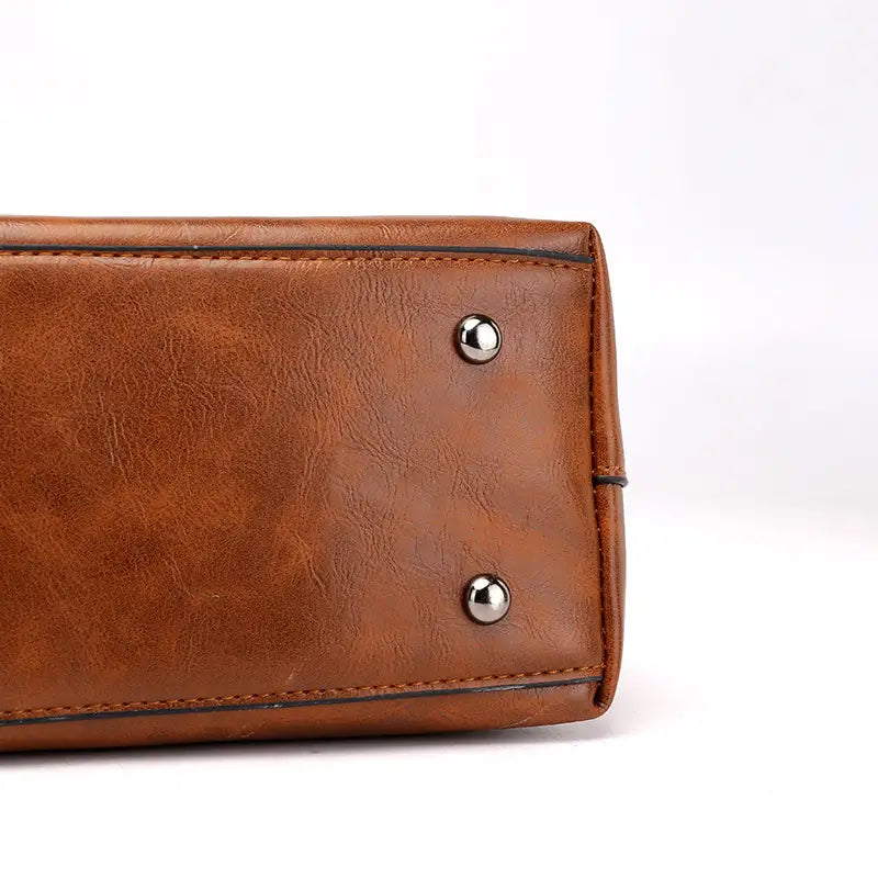 Brown leather retro large capacity tote crossbody bag featuring silver-toned metal studs.