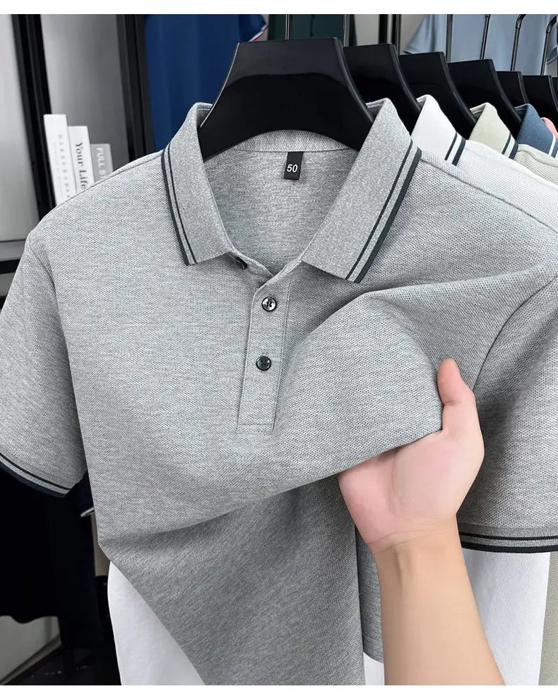 Graues mercerisiertes Baumwoll-Poloshirt mit schwarzem Besatz am Kragen und an den Ärmeln, mit Knopfleiste für eine sommerlich lockere, atmungsaktive Passform