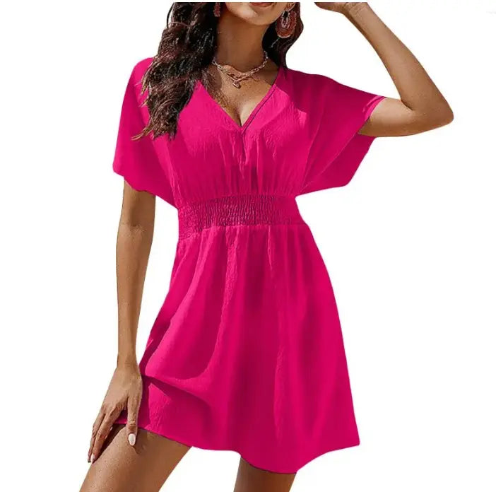 A vibrant fuchsia chiffon dress with short sleeves v-neckline and a smocked waistband featuring pleated details.