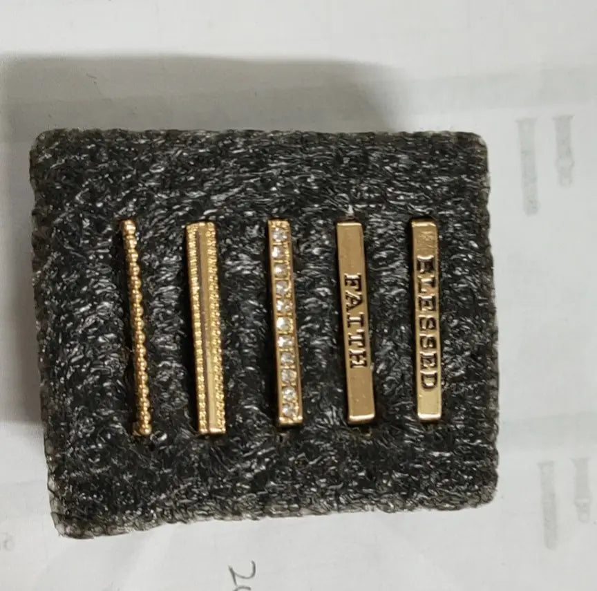 Set of five gold-toned rectangular bar earrings with silicone straps featuring beaded texture, engraved words faith and blessing, and one adorned with small clear stones from the gold embellished silicone strap decorative ring set.