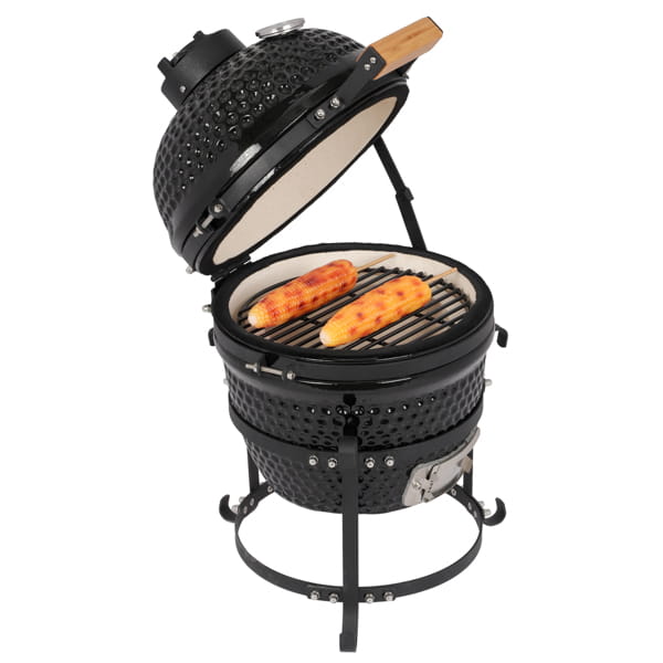 Black ceramic 13 inch kamado charcoal grill with wooden handle on the lid containing two grilled corn cobs inside.