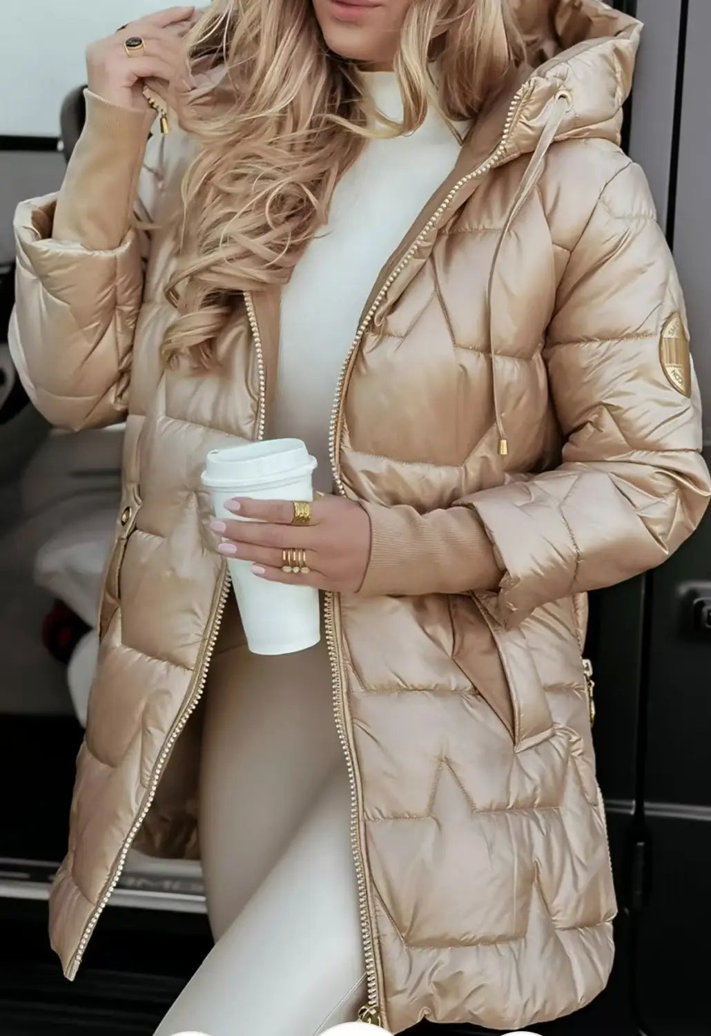 A shiny metallic gold glossy hooded down puffer jacket with a quilted design and matching zipper accents.