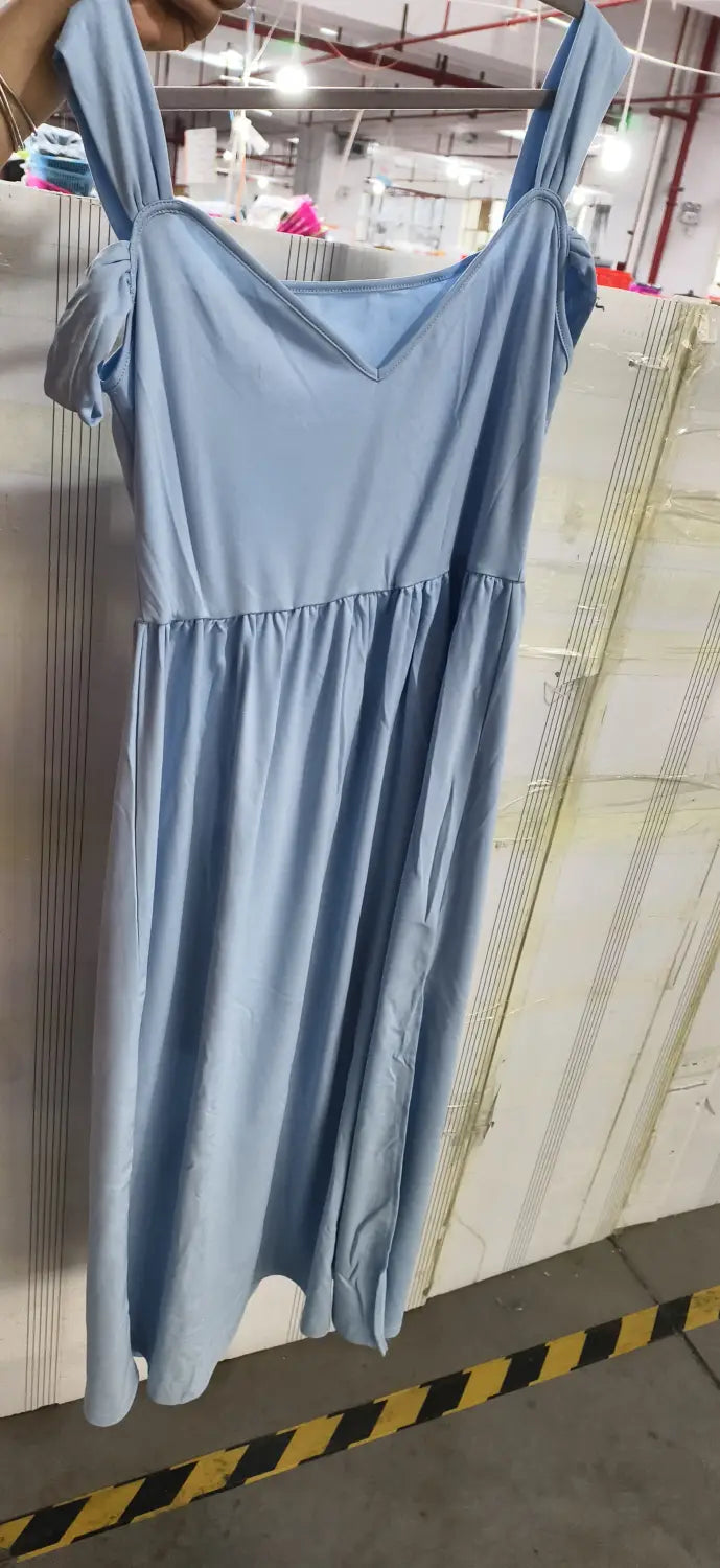 Un vestido maxi plisado floral color azul claro con diseño sin mangas, escote en V y cintura fruncida.