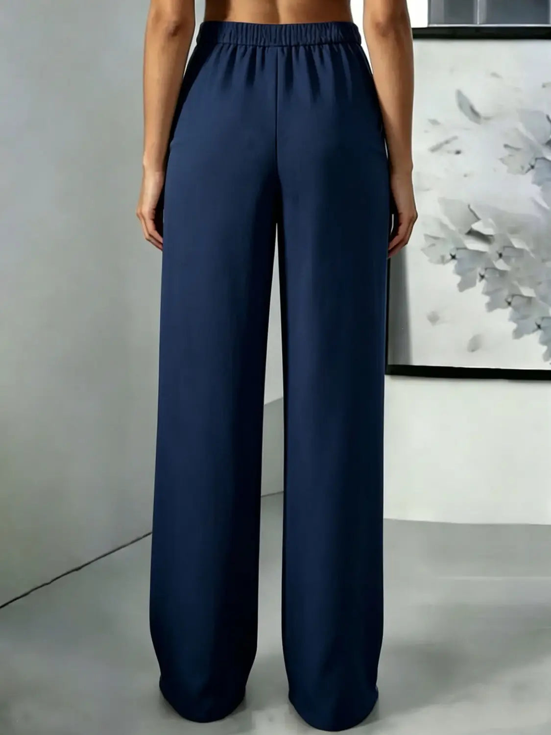 Pantalons bleu marine à jambes larges avec une ceinture élastique et une taille haute ; pantalons plissés en tissu souple, idéals pour une tenue formelle et décontractée.