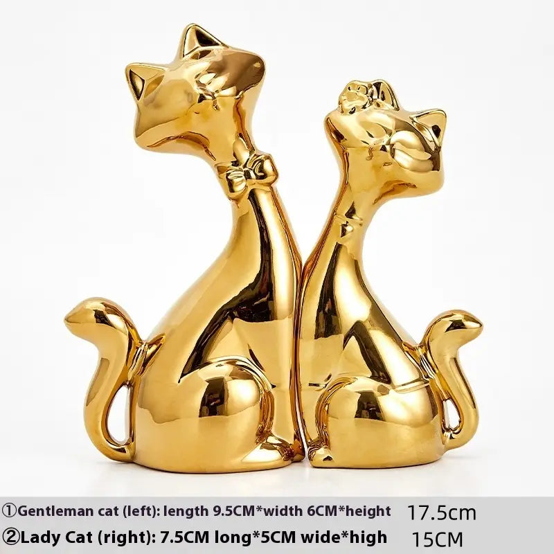 Golden ceramic cat figurines in modern gold and white home decor featuring a gentleman with a bow tie and a lady.