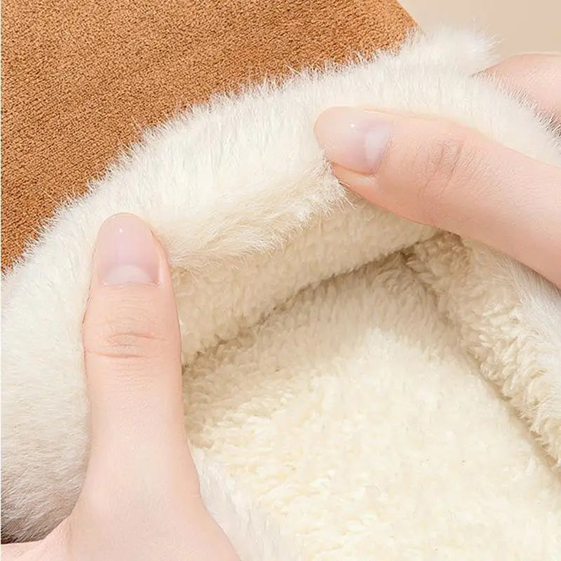 cream-colored plush interior lining of a cozy brown women’s plush suede thick sole winter house slipper.