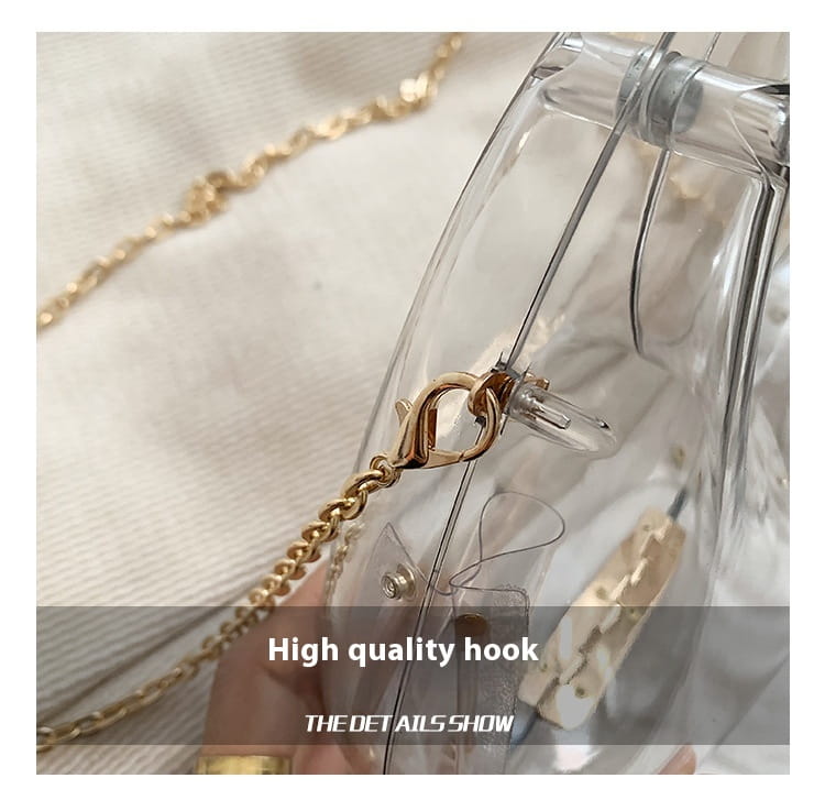 clear plastic handbag with gold-tone chain strap and matching clasp designed as an acrylic gold chain metallic clutch bag.