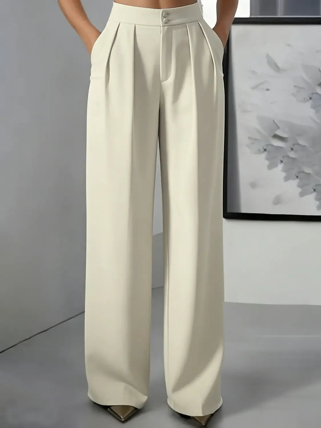 Pantalons à jambes larges couleur crème et taille haute avec un design élégant sur mesure et deux boutons à l’avant, parfaits pour un look professionnel et soigné.