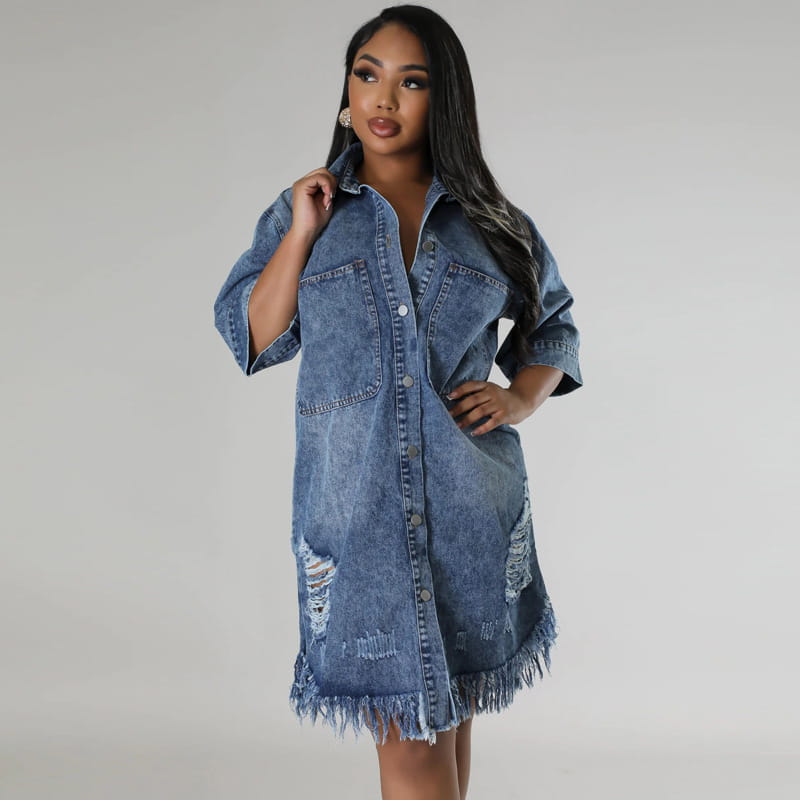 Robe chemise midi en denim bleu avec fermeture à bouton sur le devant, empiècements abîmés et ourlet effiloché.